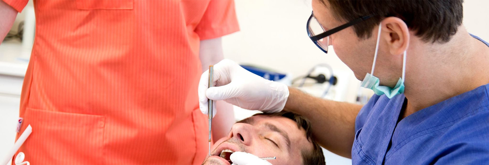 Tannlege som utfører undersøkelse på en pasient